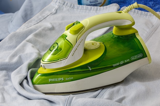 How does an iron remove wrinkles from clothes?